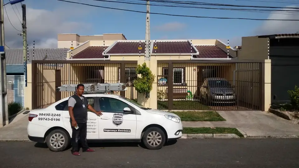 Técnico ao lado do carro da GMTEL em frente a uma casa atendida em São José dos Pinhais