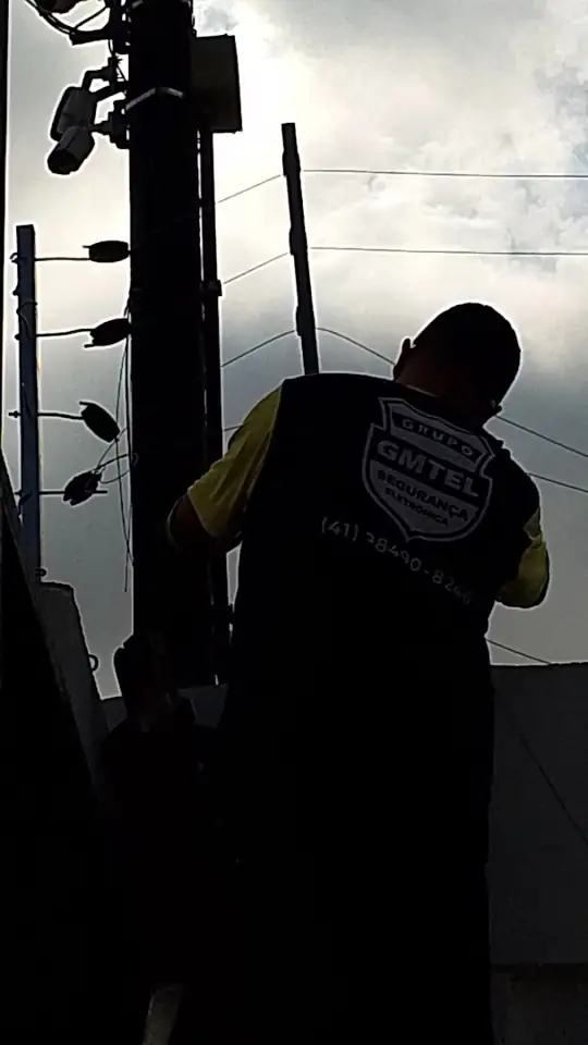 Técnico trabalhando no alto de um poste