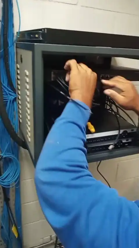 Técnico organizando cabos dentro do rack