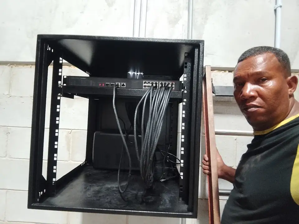 Rack de equipamentos montado, com o técnico ao lado