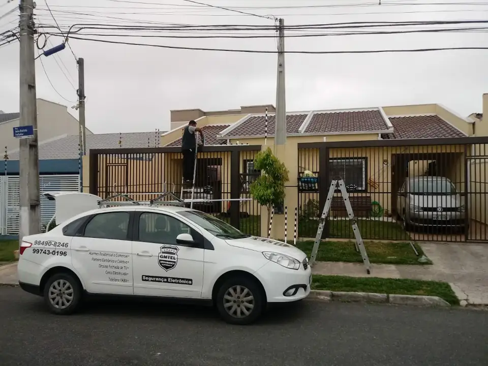 Carro da GMTEL em frente a casa enquanto a equipe instala câmera