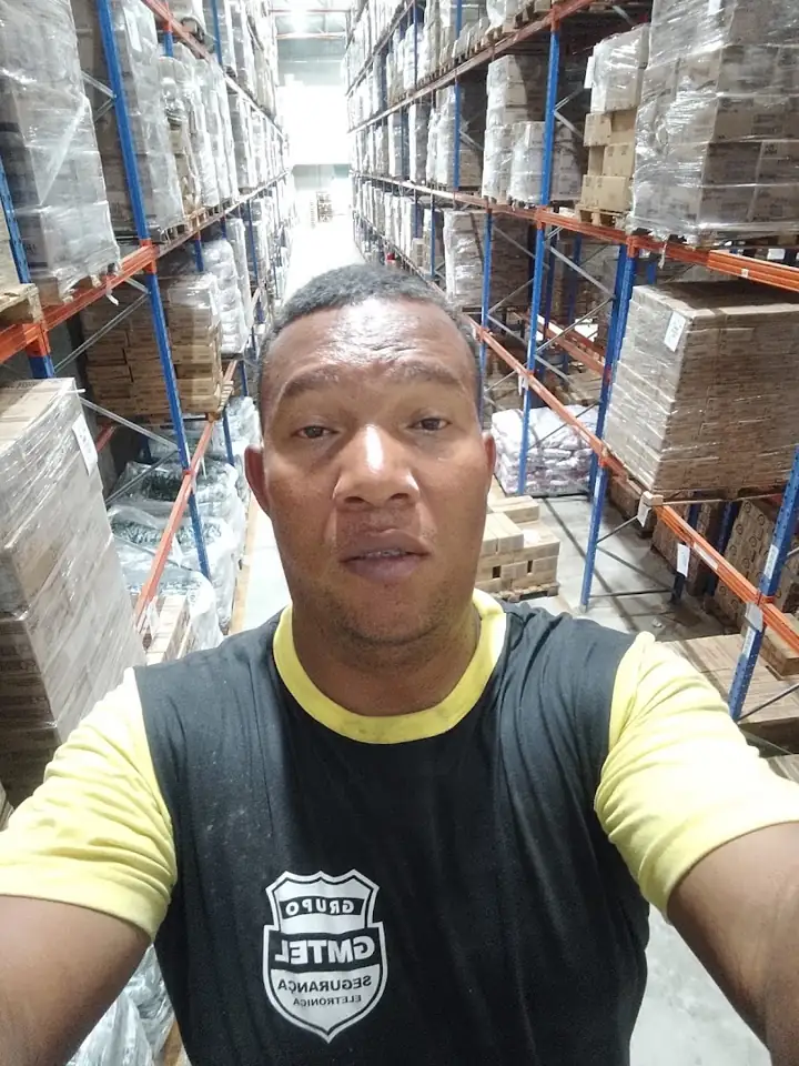 Técnico da GMTEL dentro de um galpão com prateleiras altas