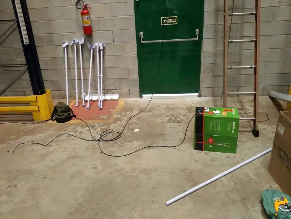 Área interna de galpão com porta de saída de emergência e materiais da instalação