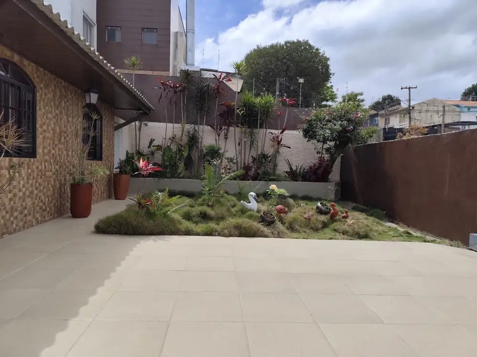 Área externa com jardim e piso, foto enviada por cliente junto com a avaliação